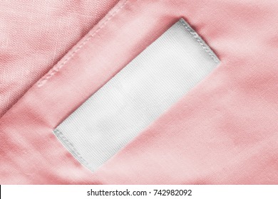 White Blank Textile Clothes Label On Pink Linen As A Background