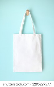 White Blank Tote Bag Mock Up Design On Blue Background Hanging On Wooden Hanger