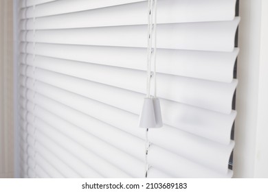 White blinds on the window with white plastic