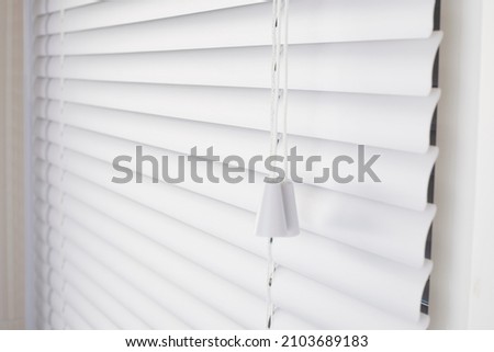 White blinds on the window with white plastic