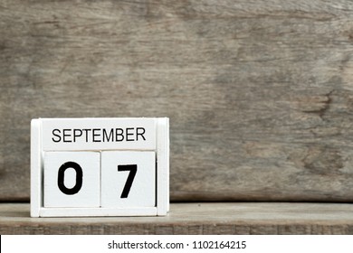White block calendar present date 7 and month September on wood background
