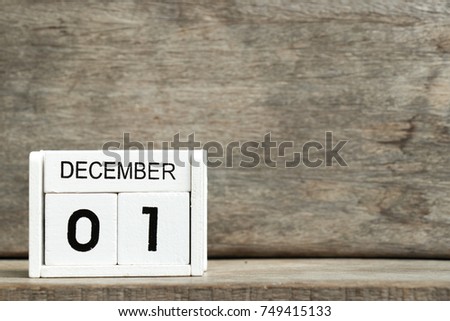 White block calendar present date 1 and month December on wood background