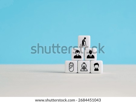White blocks stacked in a pyramid shape representing human life cycle with icons from baby to elderly on blue background