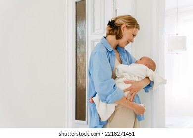 White Blonde Woman Wearing Shirt Holding Her Baby While Resting At Home