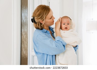 White Blonde Woman Wearing Shirt Holding Her Baby While Resting At Home