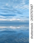 White blue clouds over lake, symmetric sky and water background, cloudscape on lake. Nature abstract, cloudy sky reflected on still water, calm tranquil concept, aesthetic panoramic view