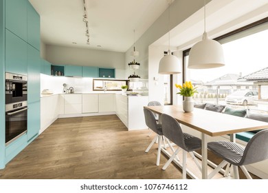 White and blue kitchen interior with big dining table, chairs and window - Powered by Shutterstock