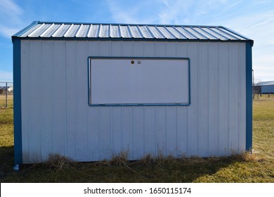 White And Blue Metal Storage Shed In A Grassy Yard