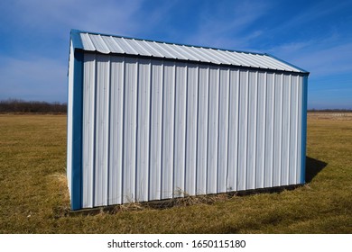 White And Blue Metal Storage Shed In A Grassy Yard