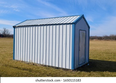 White And Blue Metal Storage Shed In A Grassy Yard