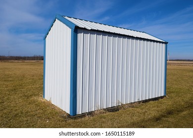 White And Blue Metal Storage Shed In A Grassy Yard