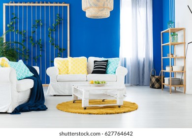 White And Blue Spacious Living Room With Yellow Additions