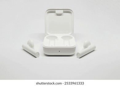 White bluetooth earbuds in isolated white background arranged symmetrically. minimalist. - Powered by Shutterstock