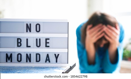 White Board With Text No Blue Monday On The Table, In The Background A Woman In Blue Clothes Depressed Near The Window,defocused.Blue Monday Day Banner Concept. Lettering