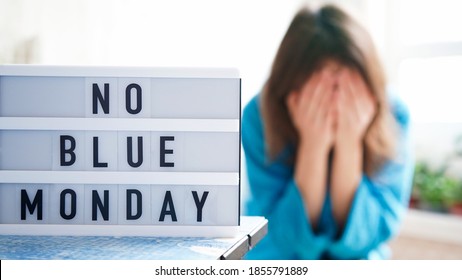 White Board With Text No Blue Monday On The Table, In The Background A Woman In Blue Clothes Depressed Near The Window,defocused.Blue Monday Day Banner Concept. Lettering