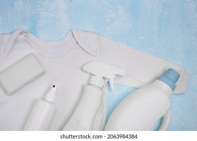White bodysuit without stains and different types of stain removers. Dirty clothes. Stubborn stains. Clean linen, bleach, yellowness of white. Soap, liquid bleach, spray bottle, household chemicals.
