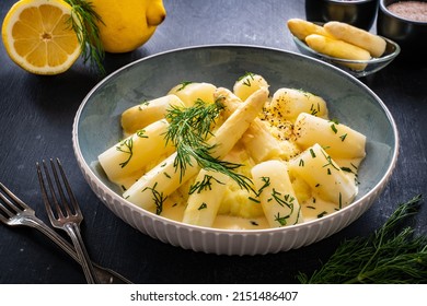 White boiled asparagus in hollandaise sauce with potato puree served on  wooden black table	