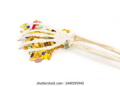 White Bony Skeleton Hand Palm Down Grabbing A Handful Of Pills
