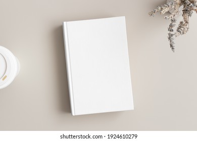 White Book Mockup With A Lavender And A Coffee Paper Cup On A Beige Table.