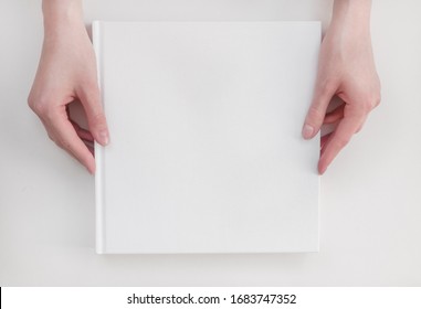 White book mockup. Square empty book. Album with clean pages in hands of woman. Clean book cover mockup