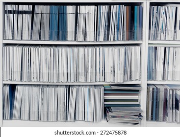 White bookcase with many reports, magazines or other publications