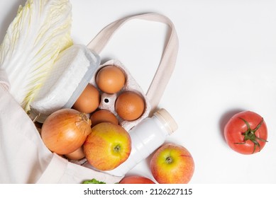 White Bottle, Apples, Onion, Tomato, Chinese Cabbage, Quark, Eggs In Tote Bag On White Background Angled Spring Fresh Products Vegetables