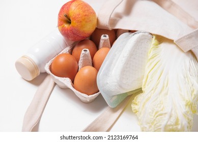 White Bottle, Chinese Cabbage, Apple, Quark, Eggs In Tote Bag On White Background Side Look Spring Fresh Products Vegetables