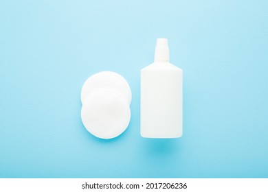 White Bottle Of Hydrogen Peroxide And Cleansing Cotton Pads On Light Blue Table Background. Pastel Color. Products For Skin Wound Cleaning. 