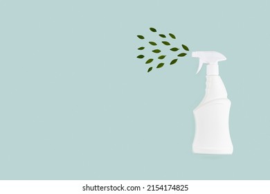 White Bottle Mockup For Cleaning. Eco Spray Bottle For Safe Cleaning With Green Leaves On Green Background. Copy Space, Flat Lay. 