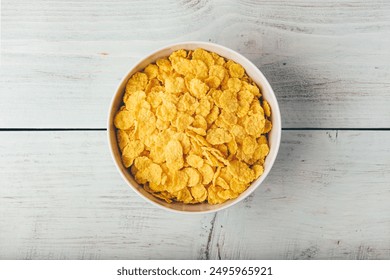 White bowl of corn flakes on a wooden surface - Powered by Shutterstock