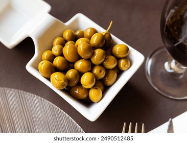 White bowl filled with marinated green olives as tangy and savory snack for wine. Mediterranean gastronomic culture - Powered by Shutterstock