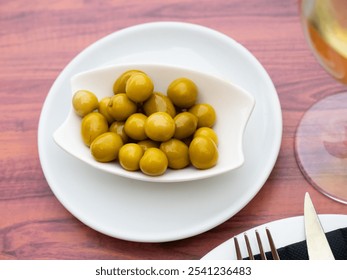 White bowl filled with marinated green olives as tangy and savory snack for wine. Mediterranean gastronomic culture - Powered by Shutterstock