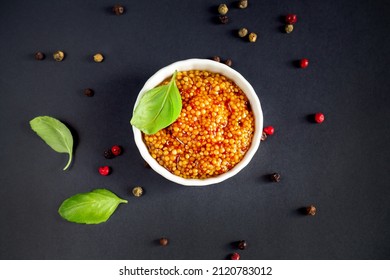 White Bowl Of French Grainy Mustard Or Dijon Mustard On Black Background. Top View