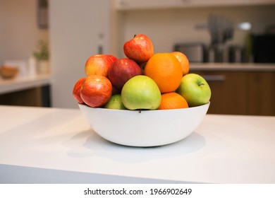 White Bowl Of Whole Fruit In The Kitchen On The Table. Green And Red Apples, And Oranges For A Healthy Diet. Kitchen Interior And Healthy Food Concept.