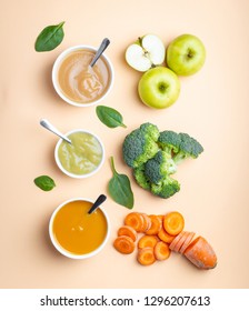 White Bowls With Healthy Natural Baby Food On Pastel Background. Purees, Made Of Fresh Organic Fruit And Vegetables, Flay Lay, Top View, Concept. Kids Food Made From Carrot, Broccoli, Apples, Spinach