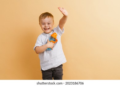 White boy with down syndrome gesturing while holding water bottle isolated over beige background - Powered by Shutterstock