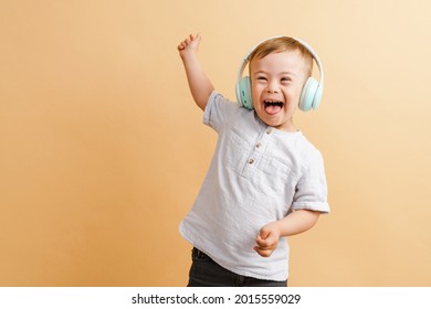 White boy with down syndrome in headphones laughing at camera isolated over beige background - Shutterstock ID 2015559029