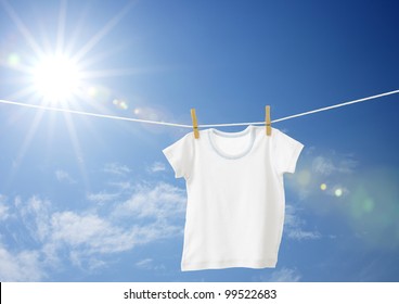 White Boys T-shirt On Clothes Line Against Blue Sky