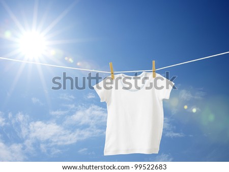 White boys T-shirt on clothes line against blue sky