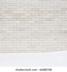 A White Brick Wall And A Ground Covered With Snow. May Use As A Background.