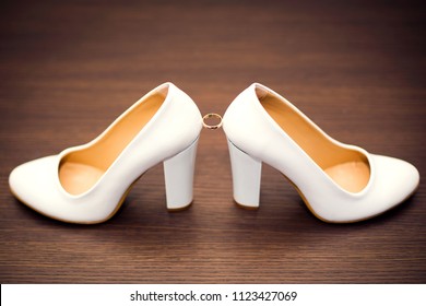 White bridal shoes and wedding rings