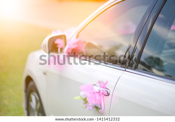 White\
bridegroom car decorated with roses and bow tie\
