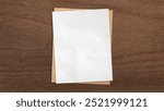 white and brown grunge paper placed on dark brown walnut wooden background. paper with blank space for add text or art works. close up of empty pieces of paper with copyspace.