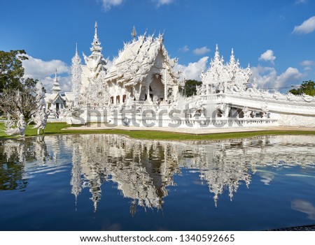 White buddhist temple reflected in the lagoon