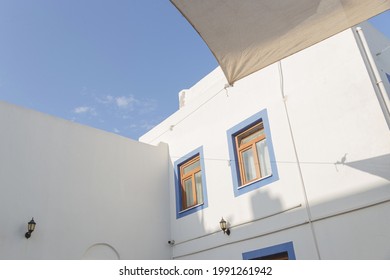 A white building with blue window frames against a blue sky in the Greek style. Travel and architecture concept. Bodrum, Turkey