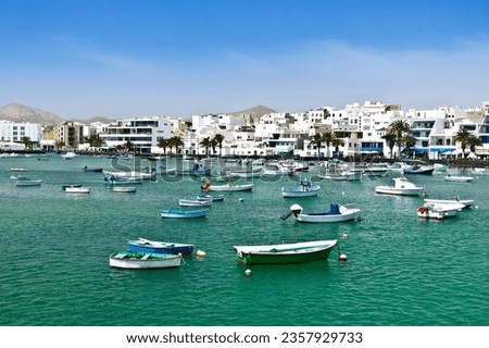 White buildings against blue sky and small fisher boats at the laguna Charco de San Gines on a sunny winter day, Arrecife, capital of Lanzarote, Spain. Foto stock © 