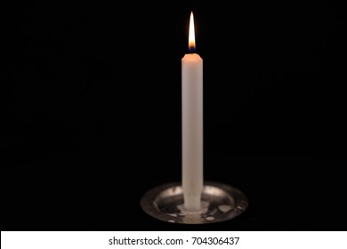 white burning candle on black isolated background. isolated object
