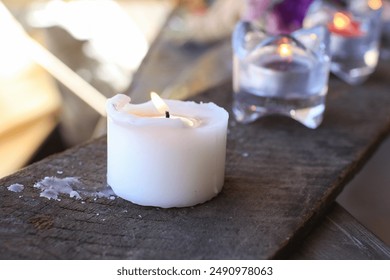 White burning candle on wooden plank. Melted Wax Candles Burning. Romantic mood on holiday vacation. - Powered by Shutterstock