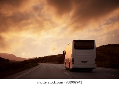 White Bus Driving On Road With Sunset View