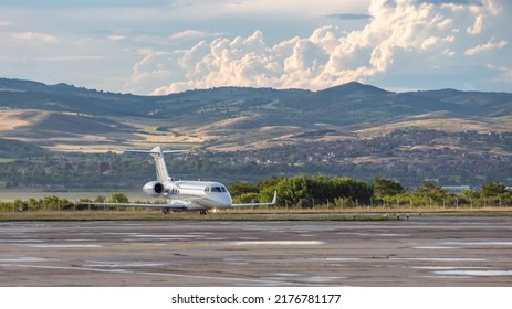 White business jet with turbofan engines on the airport with attractive panoramic mountain landscape and cloudy sky. Modern technology in fast transportation, business travel and tourism, aviation. - Powered by Shutterstock